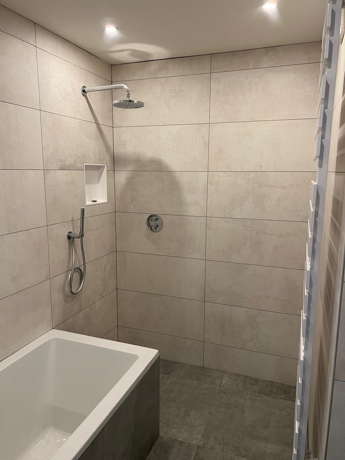 Opgeleverde badkamer met ligbad en douche