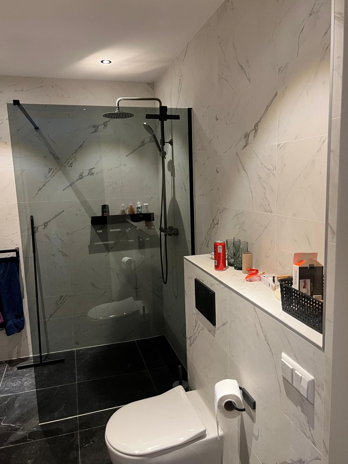 Inloopdouche met glazen wand en zwart sanitair