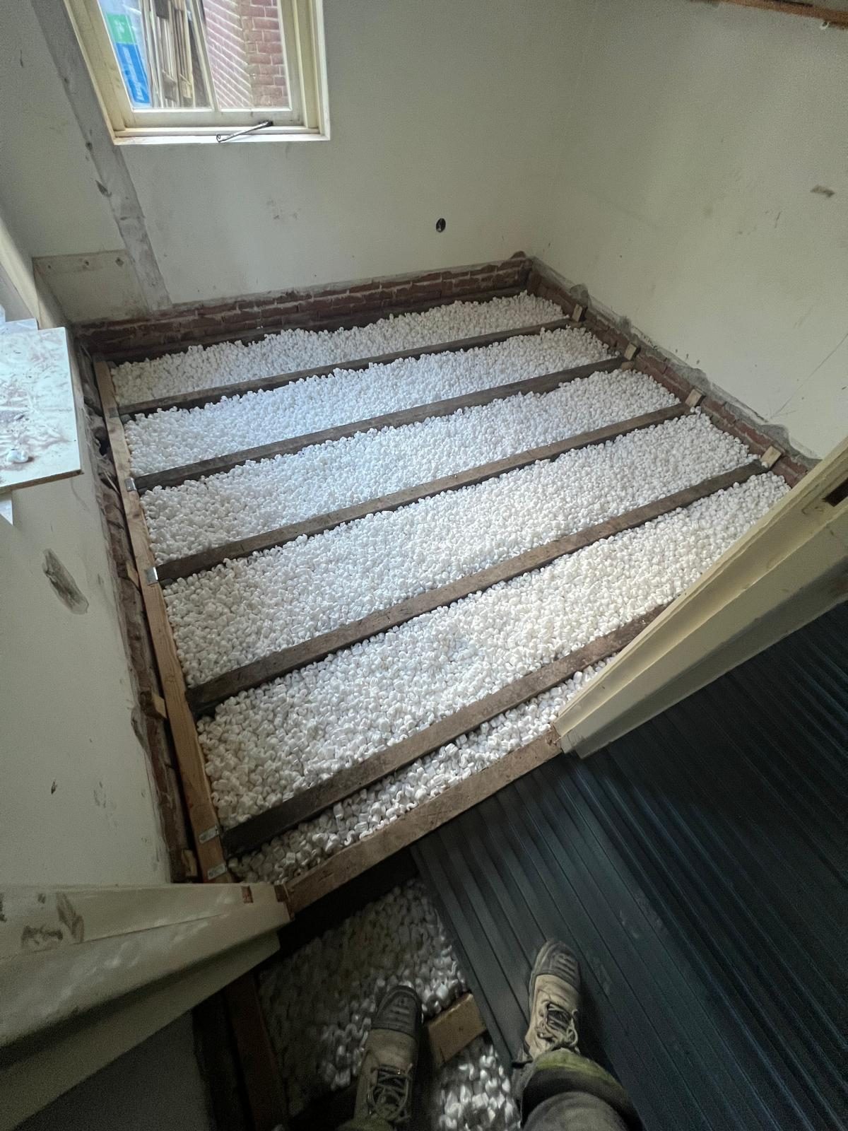 Vloerisolatie met EPS-parels tussen houten balken