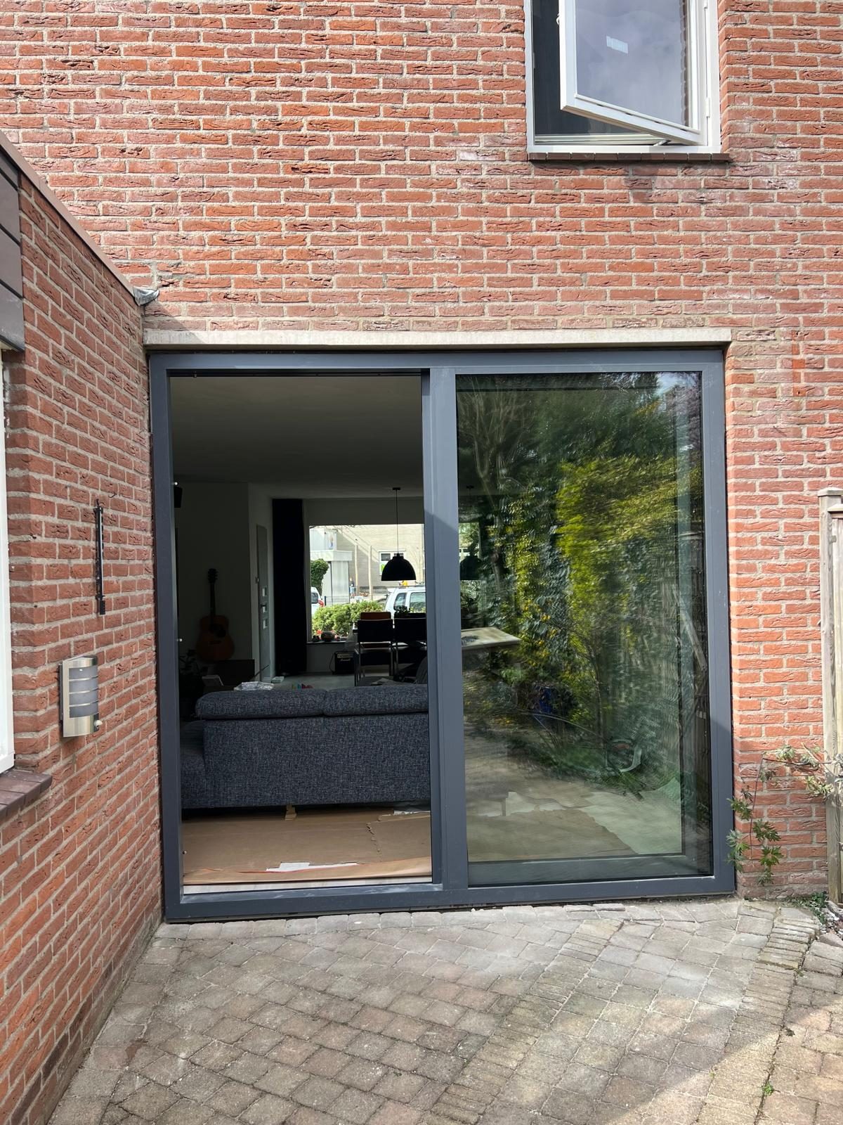 Aluminium schuifpui in een bakstenen achtergevel